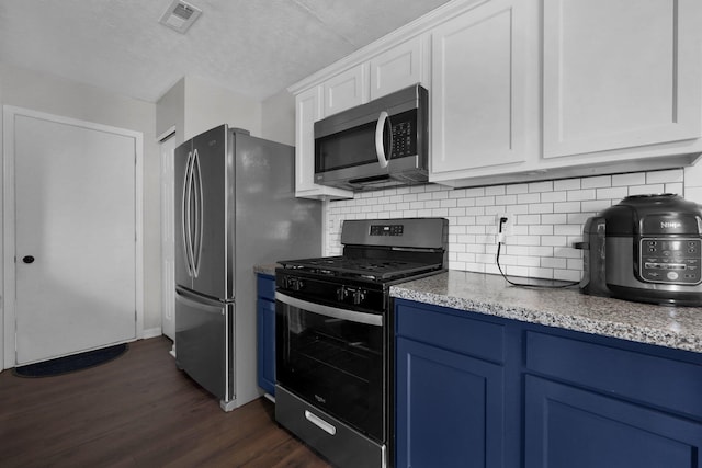 4686 Willowburn Dr, Columbus, OH 43207 - kitchen with appliances with stainless steel finishes, blue cabinets, dark wood finished floors, white cabinetry, and decorative backsplash