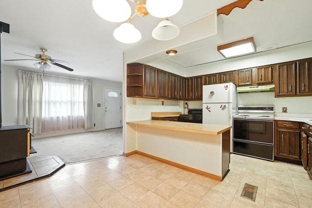 814 Gilmore Dr, Reynoldsburg, OH 43068 - kitchen featuring white appliances, under cabinet range hood, a wood stove, light countertops, and a peninsula