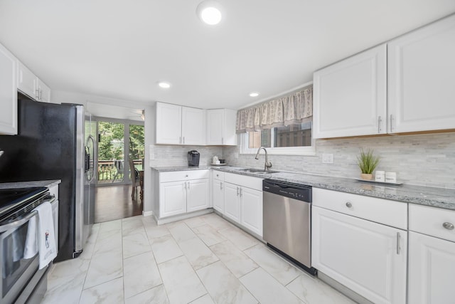 4968 Wintersong Ln Unit 10, Westerville, OH 43081 - kitchen featuring appliances with stainless steel finishes, light marble finish floors, recessed lighting, white cabinetry, and light stone counters