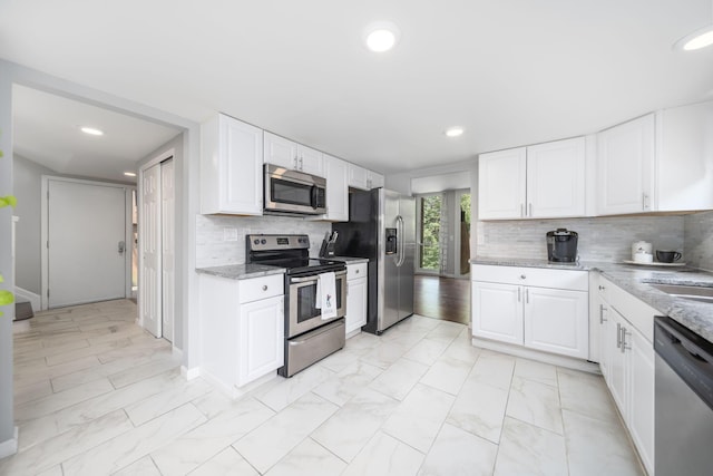 4968 Wintersong Ln Unit 10, Westerville, OH 43081 - kitchen featuring appliances with stainless steel finishes, light marble finish flooring, light stone counters, white cabinetry, and recessed lighting