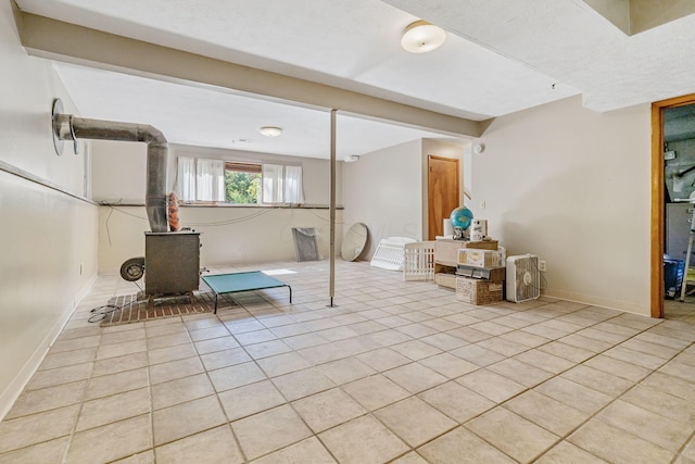 4250 Herr Fieldhouse Rd, Southington, OH 44470 - below grade area with light tile patterned floors and a wood stove