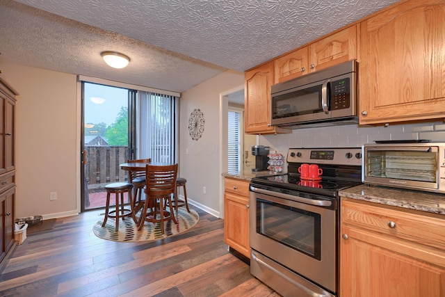 4883 Powderhorn Ln Unit 3, Westerville, OH 43081 - kitchen featuring stainless steel appliances, dark wood-style flooring, light stone countertops, and backsplash