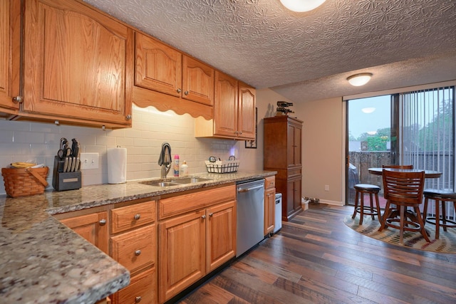 4883 Powderhorn Ln Unit 3, Westerville, OH 43081 - kitchen featuring stainless steel dishwasher, dark wood-type flooring, brown cabinetry, decorative backsplash, and light stone countertops