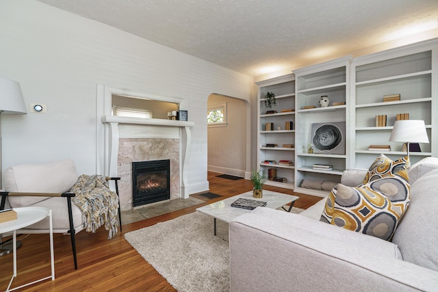 338 Sheldon Ave, Columbus, OH 43207 - living room featuring arched walkways, a textured ceiling, wood finished floors, and a premium fireplace