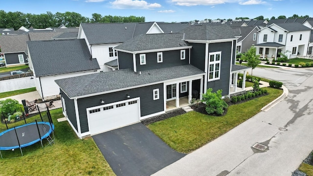 1877 Poplar Pl, Lewis Center, OH 43035 - view of front of house with a trampoline, a residential view, driveway, a porch, and a shingled roof