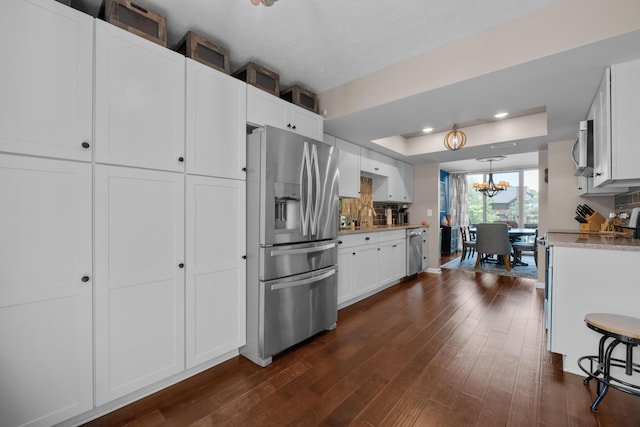 4758 Crazy Horse Ln Unit 2, Westerville, OH 43081 - kitchen featuring appliances with stainless steel finishes, a raised ceiling, a chandelier, dark wood-style flooring, and white cabinetry