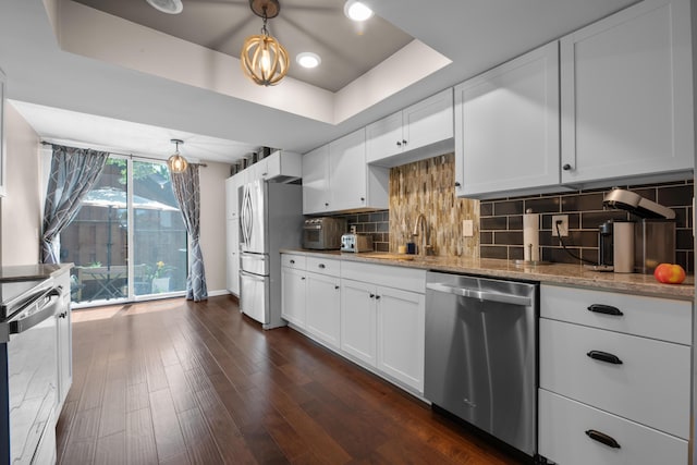 4758 Crazy Horse Ln Unit 2, Westerville, OH 43081 - kitchen featuring appliances with stainless steel finishes, a tray ceiling, light stone counters, dark wood-style flooring, and tasteful backsplash