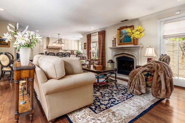 161 Jackson St, Columbus, OH 43206 - living room with a fireplace with raised hearth, hardwood / wood-style floors, recessed lighting, and crown molding