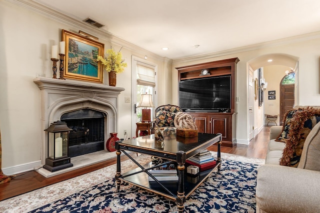 161 Jackson St, Columbus, OH 43206 - living area featuring wood finished floors, arched walkways, ornamental molding, and a fireplace with raised hearth