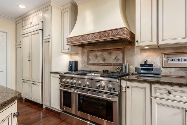161 Jackson St, Columbus, OH 43206 - kitchen with cream cabinets, high quality appliances, custom exhaust hood, dark stone countertops, and ornamental molding