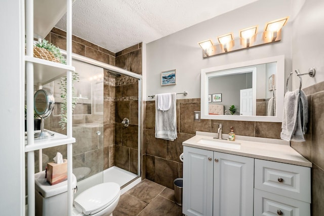 2328 Terrance Dr Unit 76, Columbus, OH 43220 - bathroom featuring tile walls, vanity, a shower stall, a textured ceiling, and tile patterned flooring