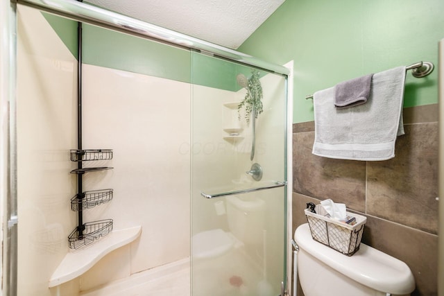 2328 Terrance Dr Unit 76, Columbus, OH 43220 - full bathroom featuring a stall shower, tile walls, and a textured ceiling
