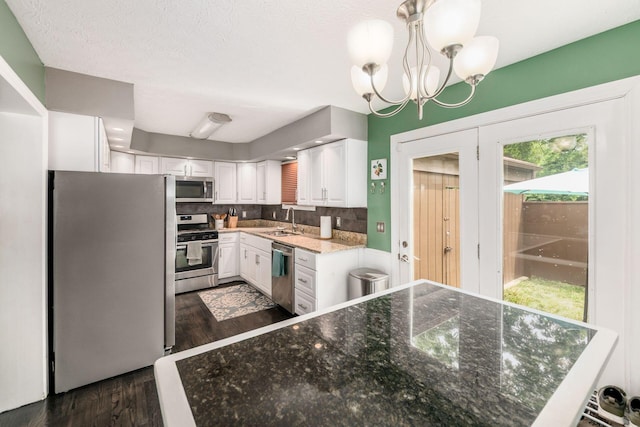 2328 Terrance Dr Unit 76, Columbus, OH 43220 - kitchen featuring appliances with stainless steel finishes, dark wood finished floors, white cabinets, backsplash, and a chandelier