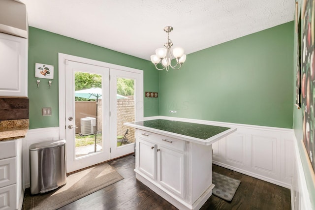 2328 Terrance Dr Unit 76, Columbus, OH 43220 - unfurnished dining area with wainscoting, dark wood finished floors, a chandelier, and a textured ceiling