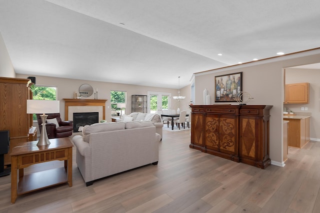 8090 Tree Lake Blvd, Powell, OH 43065 - living room featuring healthy amount of natural light, light wood finished floors, a glass covered fireplace, recessed lighting, and a chandelier
