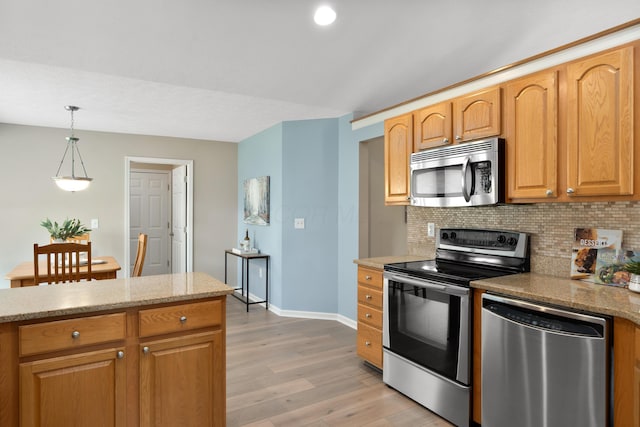 8090 Tree Lake Blvd, Powell, OH 43065 - kitchen with stainless steel appliances, light wood finished floors, decorative backsplash, hanging light fixtures, and light stone countertops