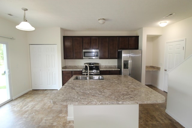 3348 Glasgow Dr, Groveport, OH 43125 - kitchen featuring stainless steel appliances, dark brown cabinetry, light countertops, decorative light fixtures, and a center island with sink