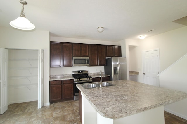 3348 Glasgow Dr, Groveport, OH 43125 - kitchen featuring appliances with stainless steel finishes, light countertops, dark brown cabinetry, and a kitchen island with sink