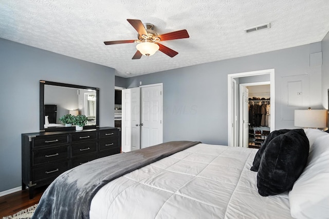 4764 Mattox St Unit 44, Columbus, OH 43228 - bedroom featuring dark wood finished floors, a textured ceiling, ceiling fan, and a spacious closet