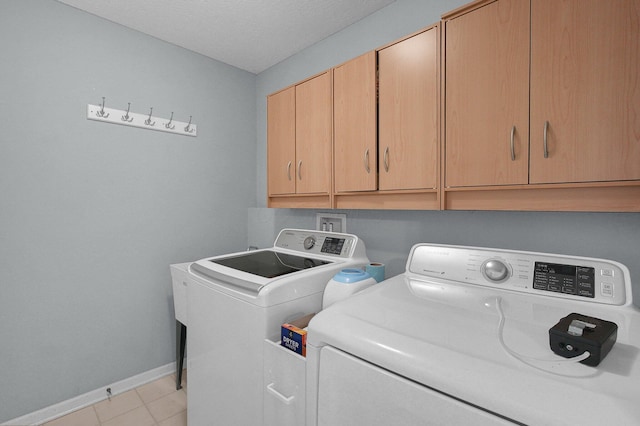 9287 Auburn Ct, Powell, OH 43065 - washroom with cabinet space, washing machine and clothes dryer, and light tile patterned flooring