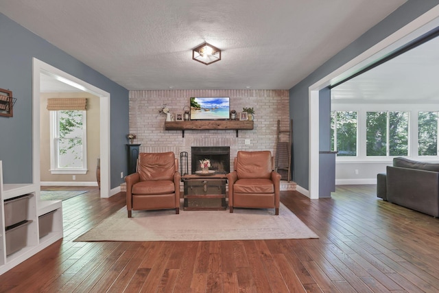 10 Denbigh Dr, Granville, OH 43023 - living area with dark wood finished floors, a textured ceiling, and a brick fireplace