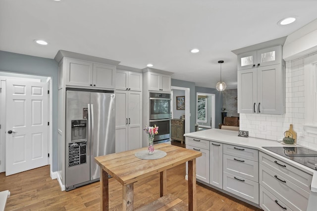 10 Denbigh Dr, Granville, OH 43023 - kitchen featuring stainless steel appliances, tasteful backsplash, light countertops, light wood-type flooring, and recessed lighting