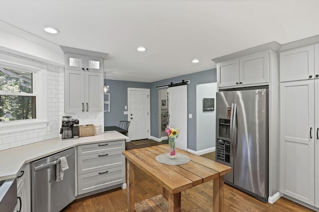 10 Denbigh Dr, Granville, OH 43023 - kitchen with appliances with stainless steel finishes, a barn door, light countertops, decorative backsplash, and recessed lighting