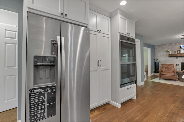 10 Denbigh Dr, Granville, OH 43023 - kitchen featuring stainless steel appliances, wood finished floors, open floor plan, white cabinets, and recessed lighting