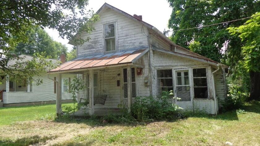 207 Nichols St, Cardington, OH 43315 - view of front of home with a porch, a front yard, a standing seam roof, a chimney, and a metal roof