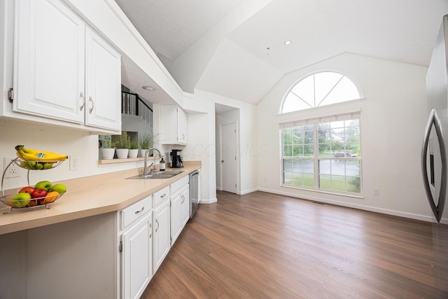 4247 Boulder Creek Dr, Columbus, OH 43230 - kitchen with dishwasher, wood finished floors, white cabinets, lofted ceiling, and light countertops