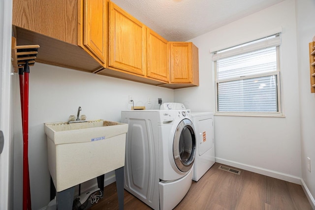 4247 Boulder Creek Dr, Columbus, OH 43230 - washroom with cabinet space, washer and clothes dryer, and wood finished floors