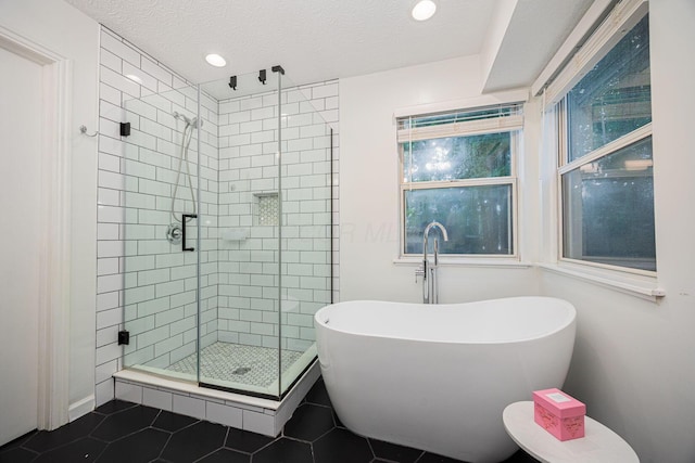 4247 Boulder Creek Dr, Columbus, OH 43230 - bathroom with a freestanding tub, a stall shower, tile patterned flooring, a textured ceiling, and plenty of natural light