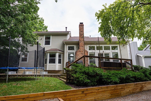 4247 Boulder Creek Dr, Columbus, OH 43230 - back of house featuring a trampoline, a chimney, a wooden deck, and a yard
