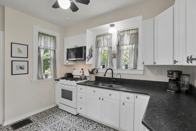 604 Elm St, Groveport, OH 43125 - kitchen with stainless steel microwave, white gas range, ceiling fan, and white cabinets