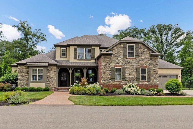 3150 Middle Pike, West Jefferson, OH 43162 - view of front facade with stone siding, a garage, stucco siding, and a shingled roof