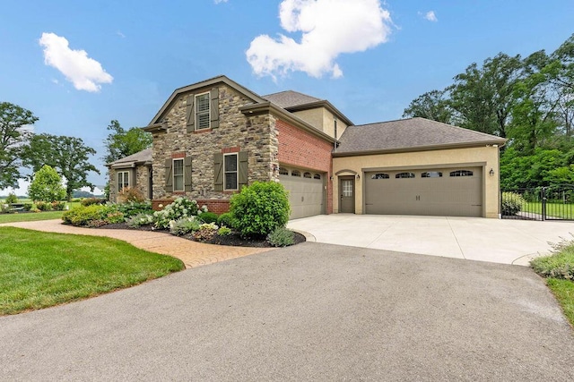 3150 Middle Pike, West Jefferson, OH 43162 - view of front of home featuring an attached garage, driveway, stucco siding, and stone siding