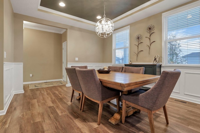 2267 Holiday Valley Dr, Grove City, OH 43123 - dining space with a raised ceiling, a chandelier, light wood finished floors, ornamental molding, and wainscoting
