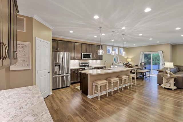 2267 Holiday Valley Dr, Grove City, OH 43123 - kitchen featuring stainless steel appliances, open floor plan, a breakfast bar area, recessed lighting, and ornamental molding