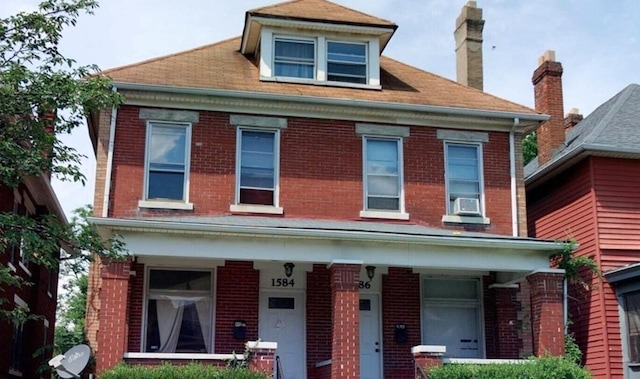1584 Bryden Rd, Columbus, OH 43205 - view of front of home with brick siding, cooling unit, a porch, and a chimney