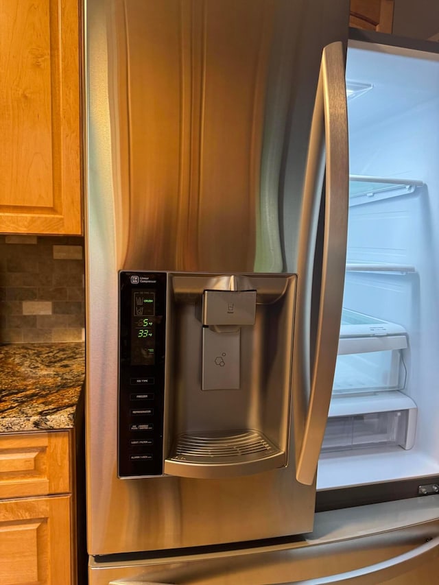 5542 Emerson Ave, Worthington, OH 43085 - kitchen view of stainless steel fridge, decorative backsplash, and dark stone countertops