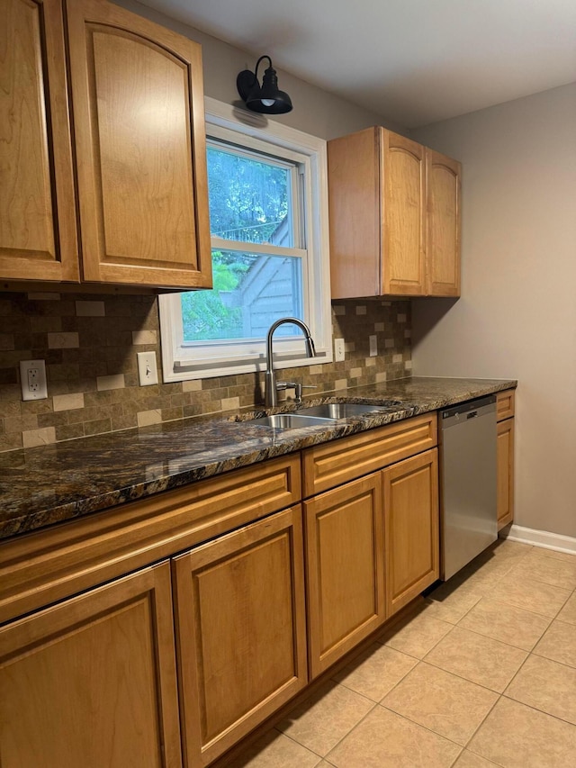 5542 Emerson Ave, Worthington, OH 43085 - kitchen with stainless steel dishwasher, backsplash, light tile patterned floors, and dark stone countertops