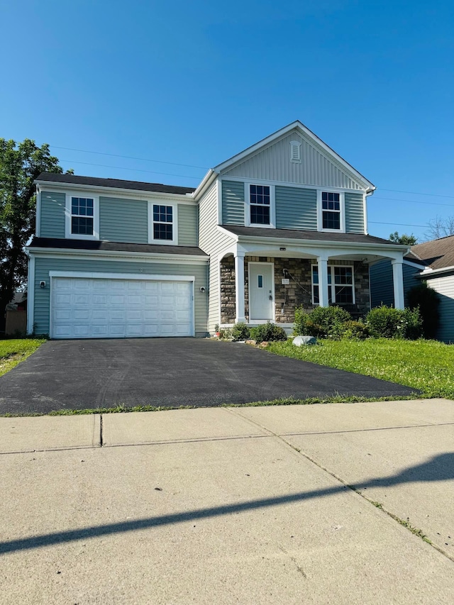 7173 Serenoa Dr, Reynoldsburg, OH 43068 - view of front of property with driveway, an attached garage, stone siding, and a porch