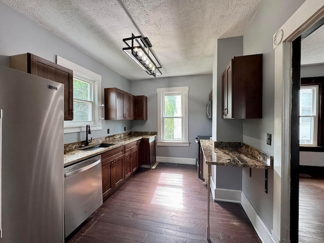 940 W 3rd St, Logan, OH 43138 - kitchen with stainless steel appliances, plenty of natural light, a textured ceiling, dark wood-style flooring, and dark stone countertops
