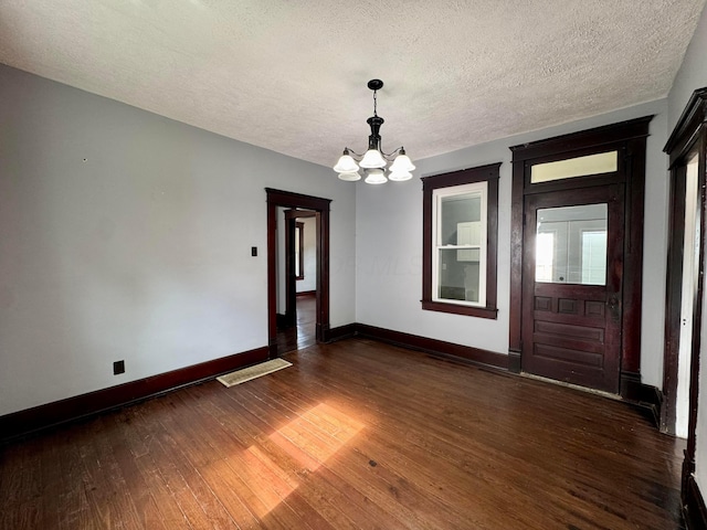 940 W 3rd St, Logan, OH 43138 - spare room with a chandelier, dark wood-style flooring, and a textured ceiling