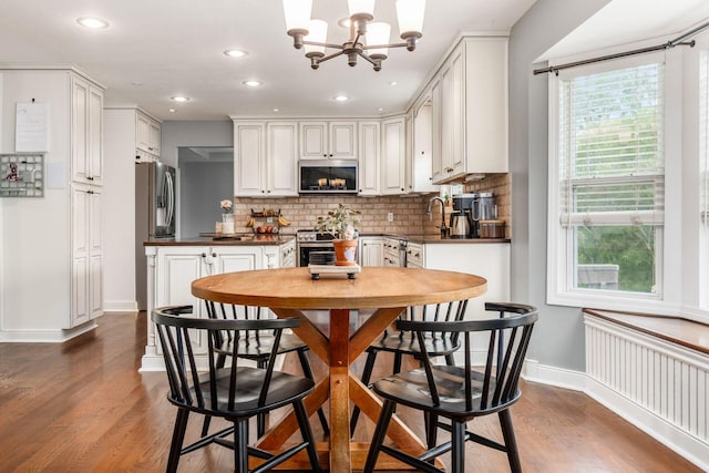 2063 Hayer Ct, Lewis Center, OH 43035 - kitchen featuring stainless steel appliances, radiator heating unit, dark countertops, backsplash, and dark wood-type flooring
