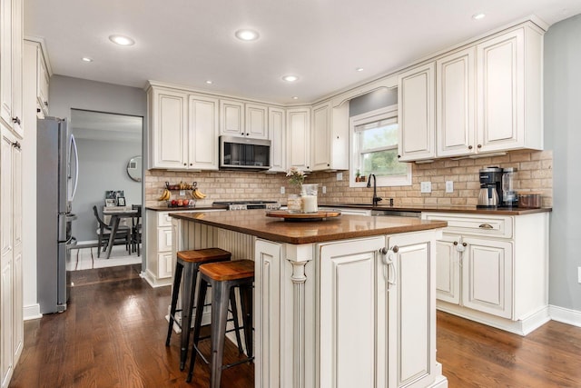 2063 Hayer Ct, Lewis Center, OH 43035 - kitchen with stainless steel appliances, dark wood-style flooring, decorative backsplash, a kitchen island, and recessed lighting