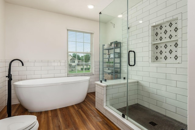 2063 Hayer Ct, Lewis Center, OH 43035 - bathroom featuring wood finished floors, tile walls, a stall shower, a freestanding bath, and recessed lighting
