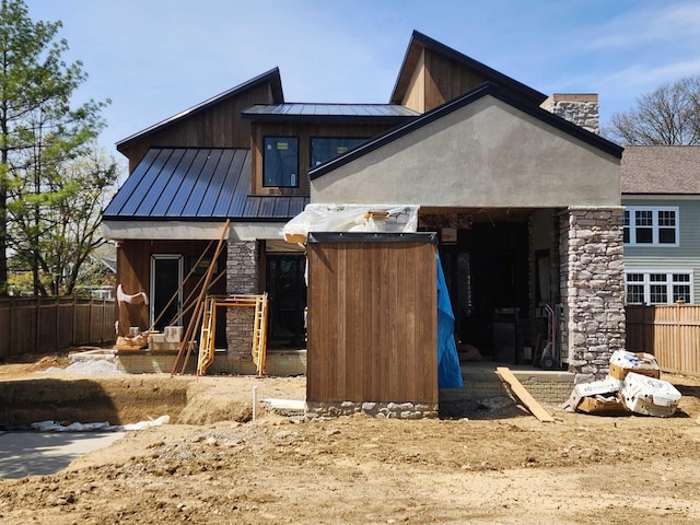 3134 Asbury Dr, Upper Arlington, OH 43221 - rear view of house featuring stone siding, a chimney, a standing seam roof, and a metal roof