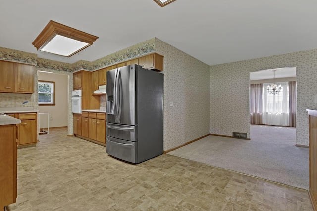 19 Kirby Rd, Heath, OH 43056 - kitchen with stainless steel fridge, oven, a chandelier, light countertops, and wallpapered walls
