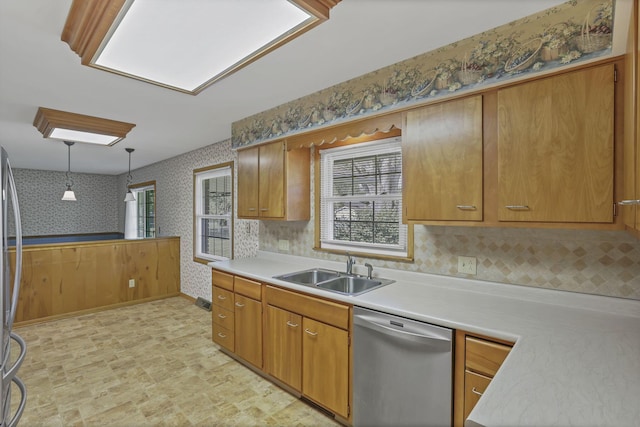 19 Kirby Rd, Heath, OH 43056 - kitchen featuring stainless steel dishwasher, wallpapered walls, light countertops, hanging light fixtures, and brown cabinetry